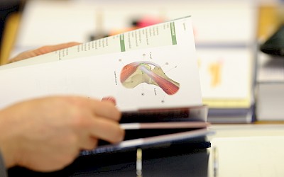 Ein Teilnehmer blättert durch ein Anatomiebuch